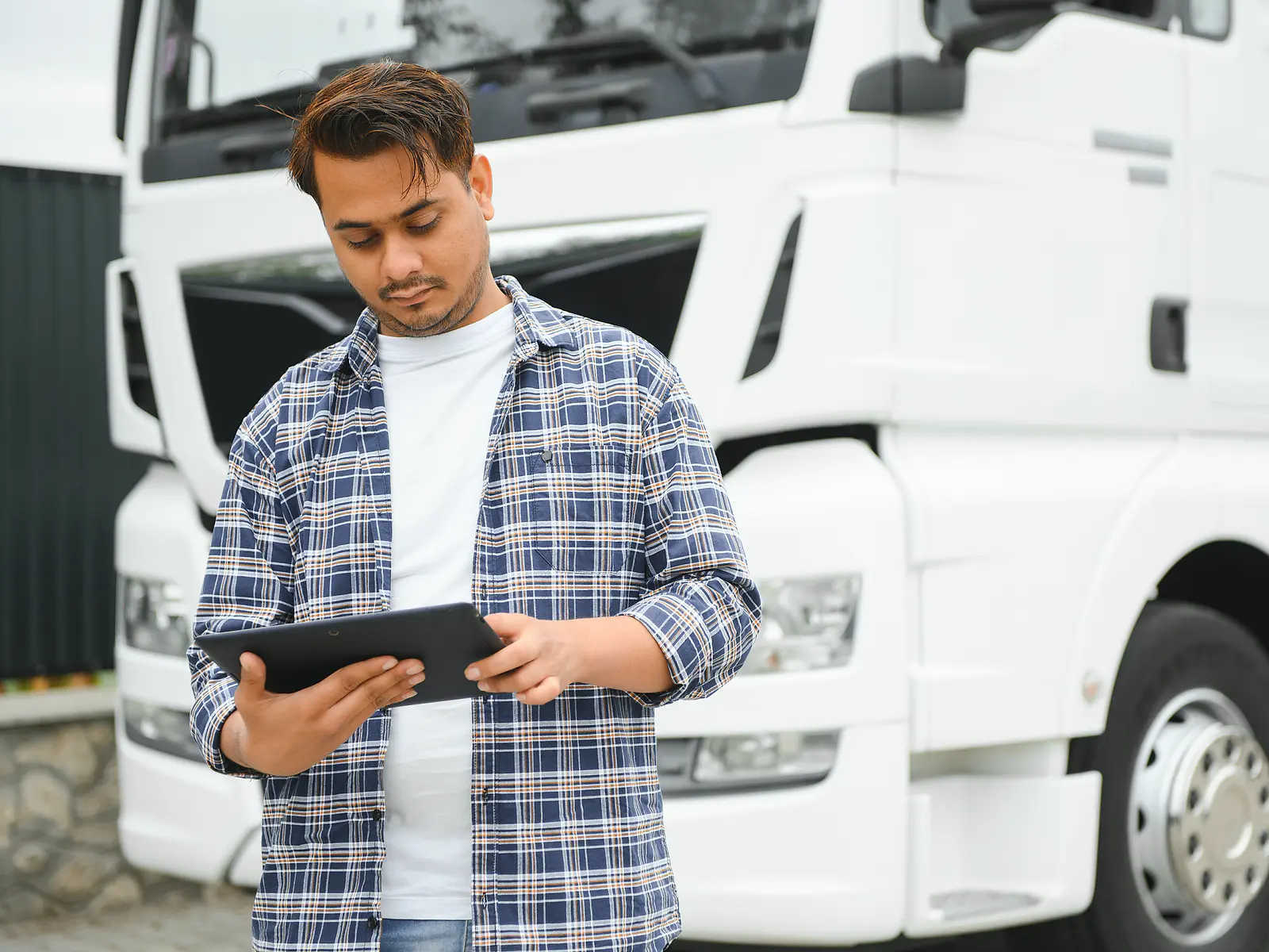 Operatore che consulta un tablet davanti a un camion bianco