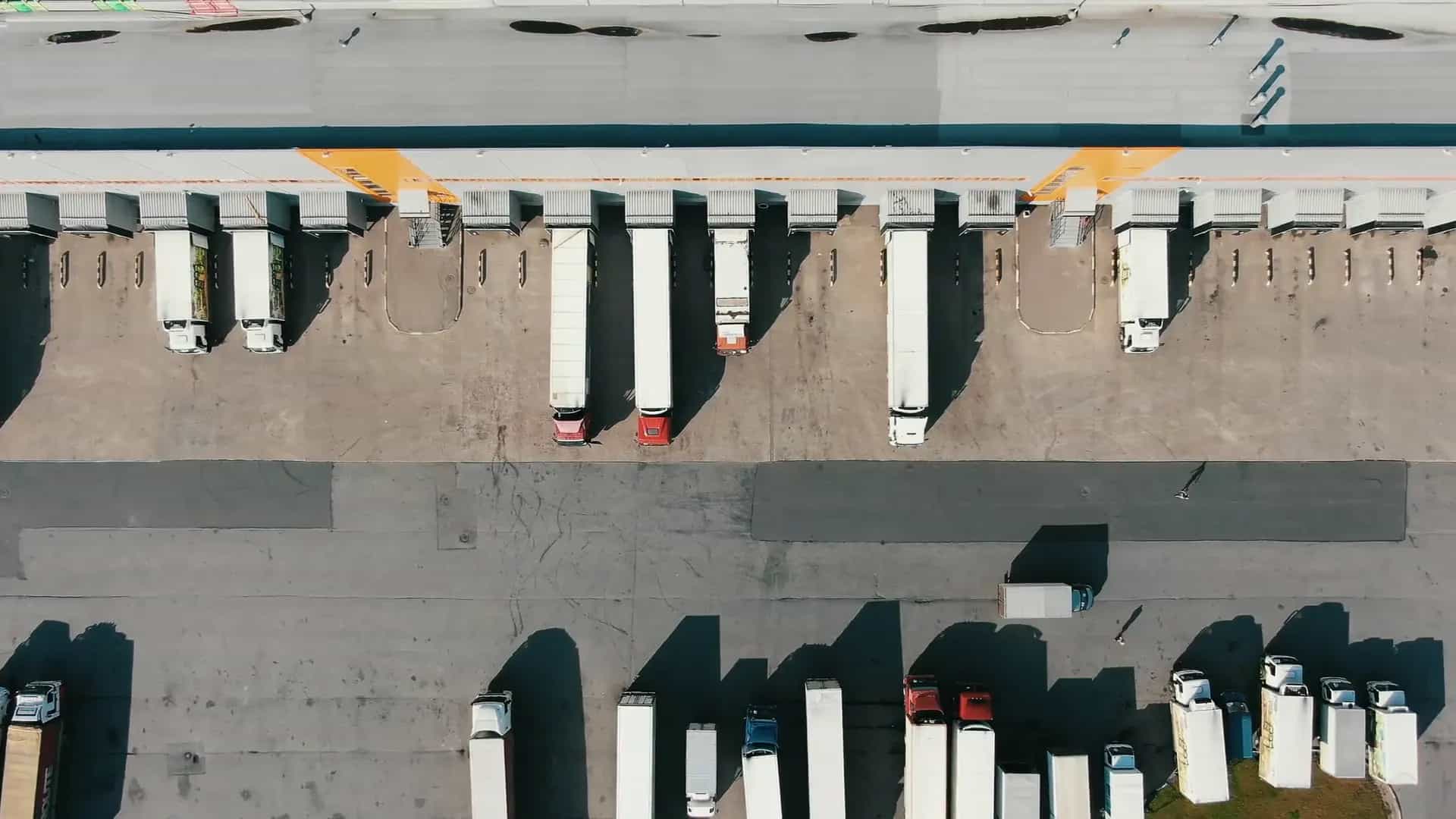 Flotta di veicoli commerciali che lascia un hub logistico europeo all'alba